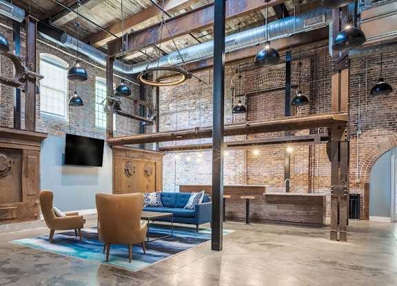 Newry Mill fully furnished rustic style lounge with two chairs, coffee table, a couch along with a television.