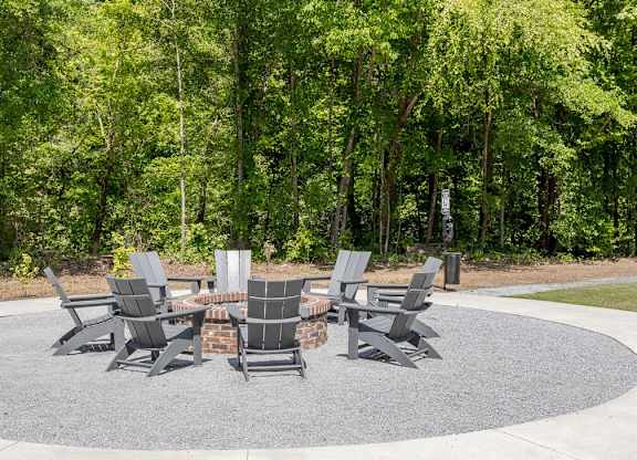 a group of chairs around a table in a park