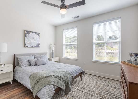 a bedroom with a bed and a ceiling fan