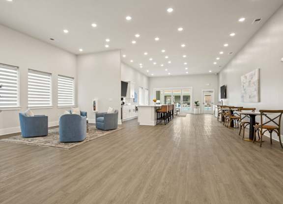 A spacious room with wooden floors and furniture.