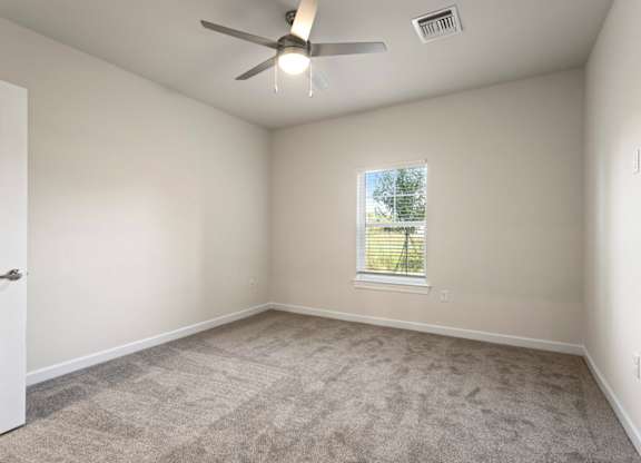 Peaks of Lexington Apartments Bedroom with Ceiling Fan, Light, Window and Gray Carpet and Connected Bathroom