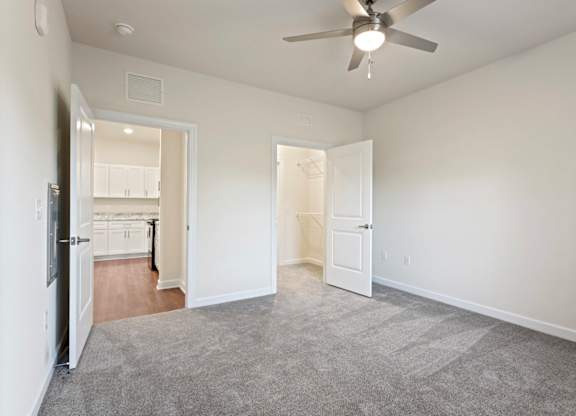 Peaks of Lexington Apartments Kitchen with Black Appliances, Granite Countertops and White Cabinetry, walk-in closet and connected living room
