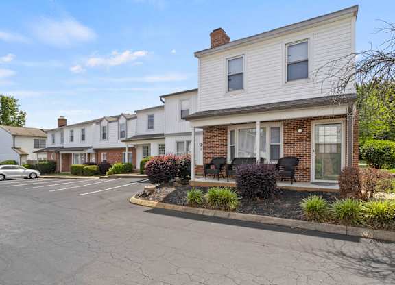 A row of houses with a car parked in front of them.
