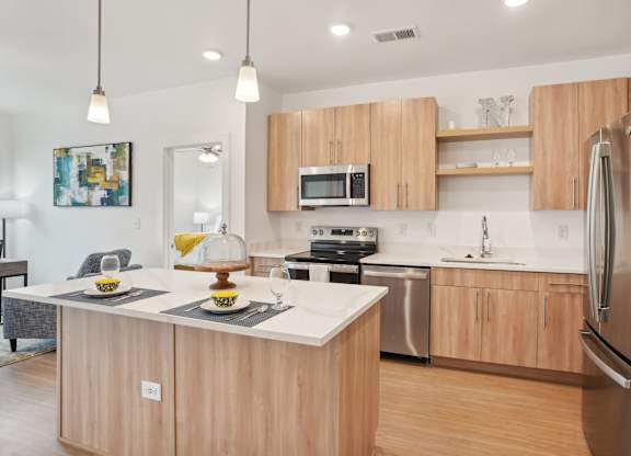 A modern kitchen with wooden cabinets and stainless steel appliances.