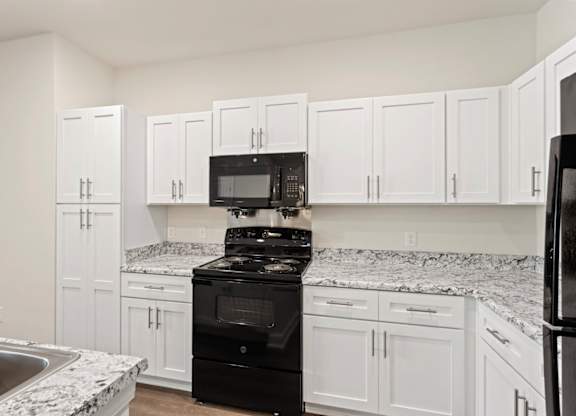 Peaks of Lexington Apartments Kitchen with Black Appliances, Granite Countertops and White Cabinetry