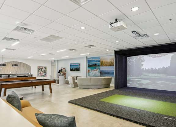 1 Bedroom Apartments in Greenville, SC | Flathouse Studios | Gaming Lounge with Foosball, Shuffleboard, Billiards, and Full Swing Golf Simulator.
