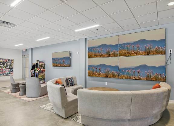 a waiting room with couches and chairs and paintings on the wall
