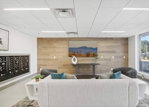 a living room with a couch and a table in front of a wooden wall