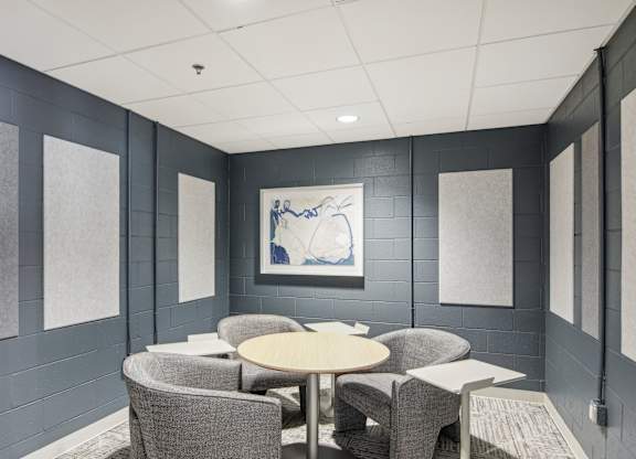 a meeting room with chairs and tables and a painting on the wall
