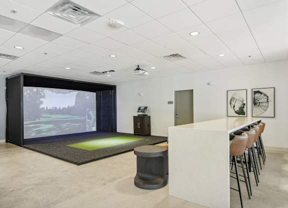 a room with a bar and a projection screen on the wall