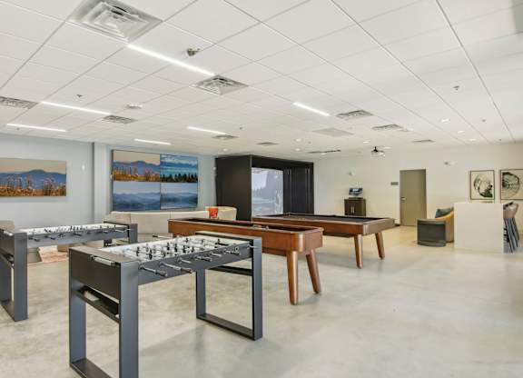 a conference room with tables and chairs and paintings on the wall