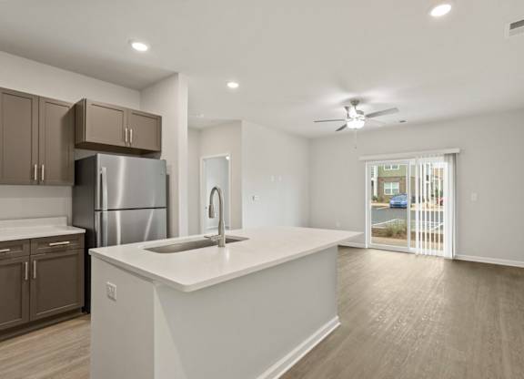 A kitchen with a white countertop and a stainless steel refrigerator.