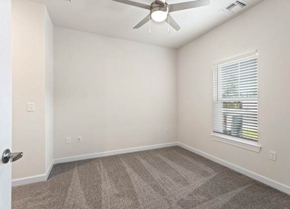 Peaks of Lexington Apartments Bedroom with Ceiling Fan, Light, Window and Gray Carpet