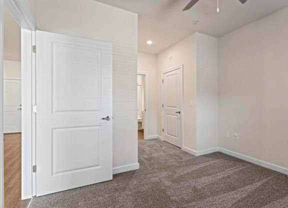 Peaks of Lexington Apartments Bedroom with Ceiling Fan, Light, Window and Gray Carpet and Connected Bathroom