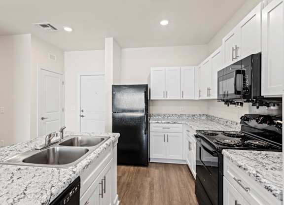 Peaks of Lexington Apartments Kitchen with Black Appliances, Granite Countertops and White Cabinetry