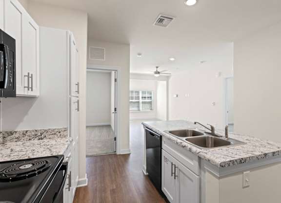 Peaks of Lexington Apartments Kitchen with Black Appliances, Granite Countertops and White Cabinetry