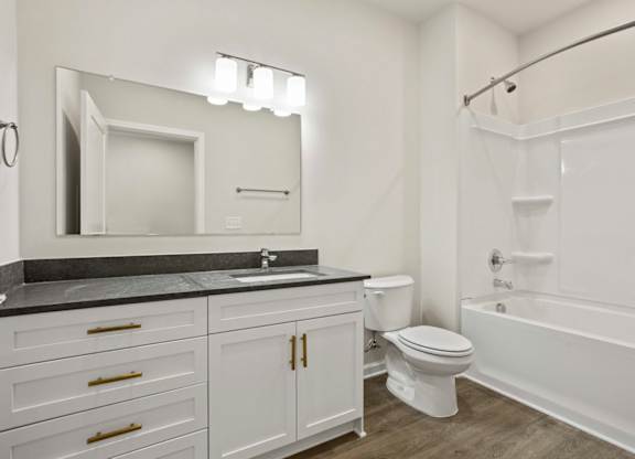 A bathroom with a sink, toilet, and bathtub.