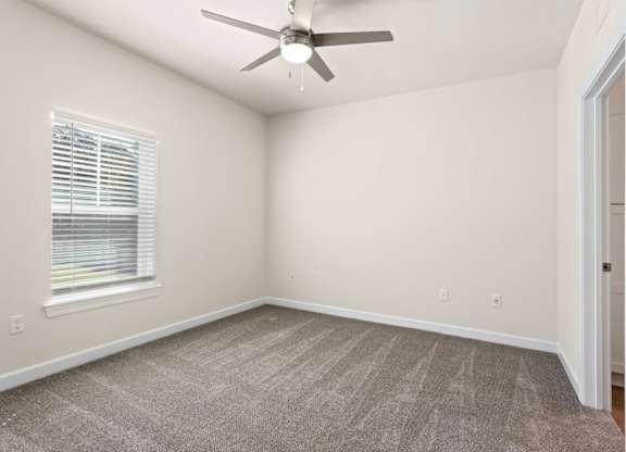 Peaks of Lexington Apartments Bedroom with Ceiling Fan, Light, Window and Gray Carpet and Connected Bathroom