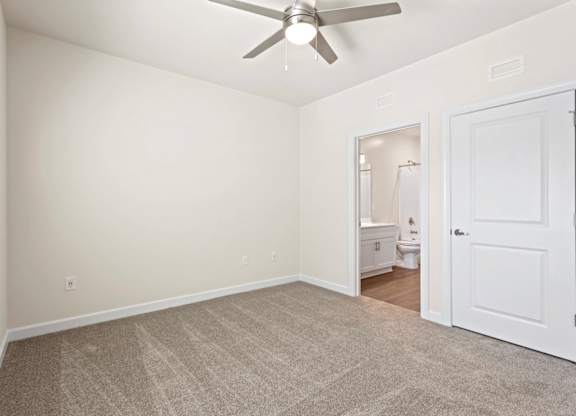 Peaks of Lexington Apartments Bedroom with Ceiling Fan, Light, Window and Gray Carpet and Connected Bathroom