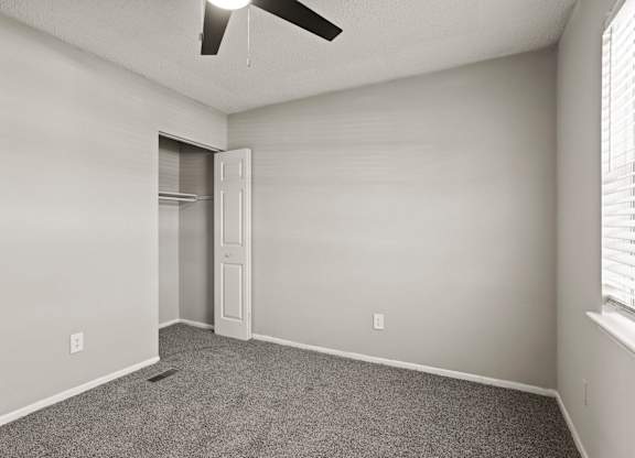 A room with a ceiling fan and a door.