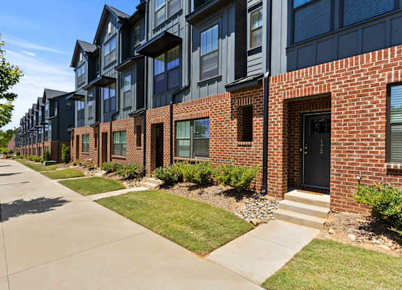 A row of modern brick and black apartment buildings.