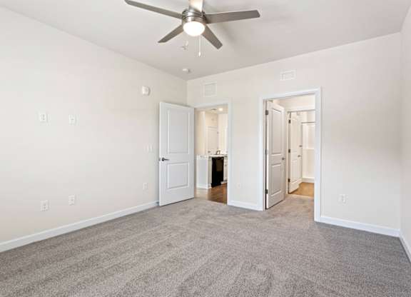 Peaks of Lexington Apartments Kitchen with Black Appliances, Granite Countertops and White Cabinetry and connected living room