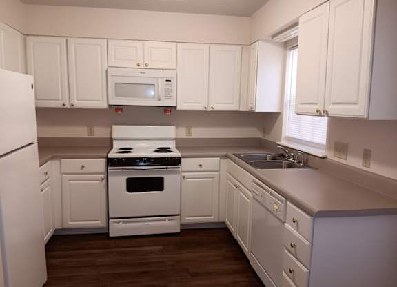 a kitchen with white cabinets and a stove and a sink