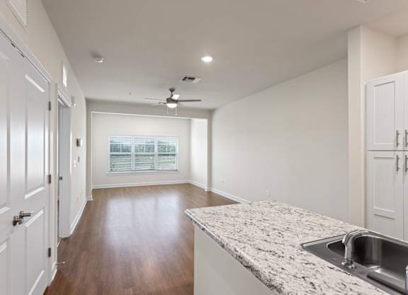 Peaks of Lexington Apartments Kitchen with Black Appliances, Granite Countertops and White Cabinetry and connected living room