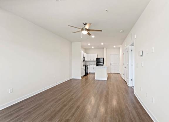 Peaks of Lexington Apartments Kitchen with Black Appliances, Granite Countertops and White Cabinetry and connected living room