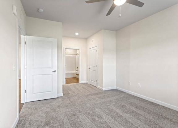 Peaks of Lexington Apartments Bedroom with Ceiling Fan, Light, Window and Gray Carpet and Connected Bathroom