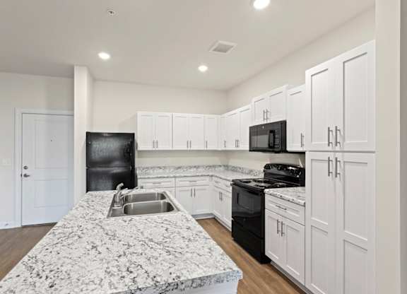 Peaks of Lexington Apartments Kitchen with Black Appliances, Granite Countertops and White Cabinetry