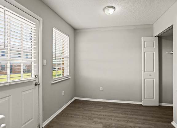 A room with a door, window, and a light on the ceiling.