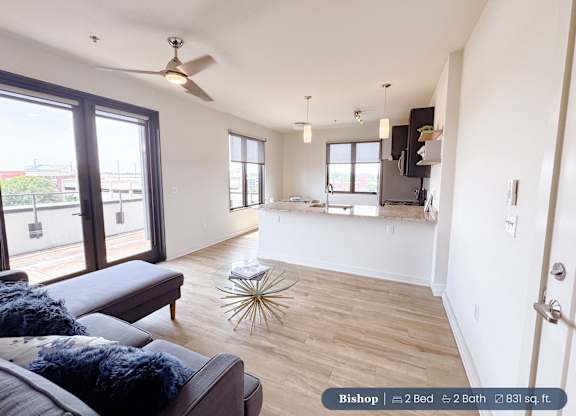 A living room with a couch and a fan.