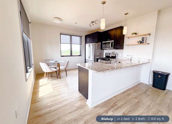 A kitchen with a refrigerator, microwave, and oven.
