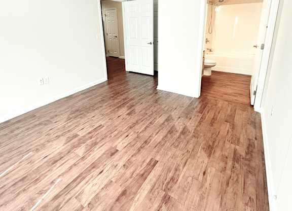 A room with wooden flooring and a ceiling fan.