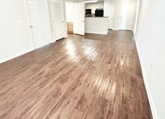 A room with wooden flooring and white walls.