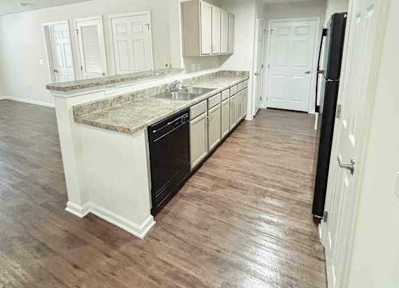 A kitchen with black appliances and white cabinets.
