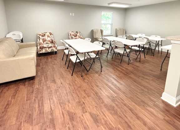 A room with a couch, chairs, and tables.