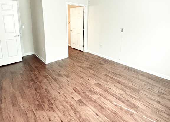 A room with a ceiling fan and wooden flooring.