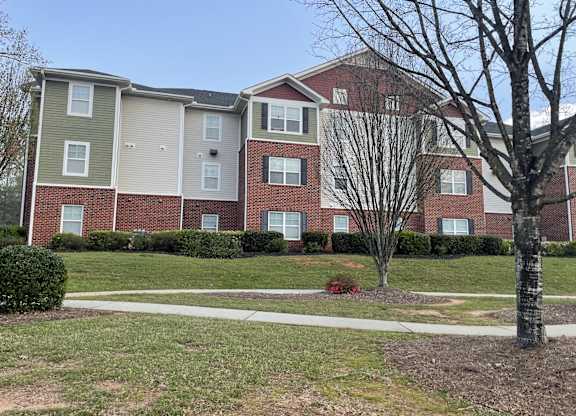 an apartment building with a sidewalk in front of it