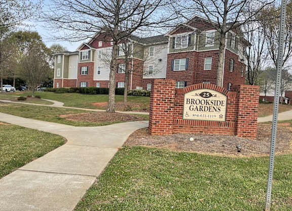 a brick sign in front of an apartment building
