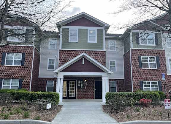 a large brick house with a sidewalk in front of it