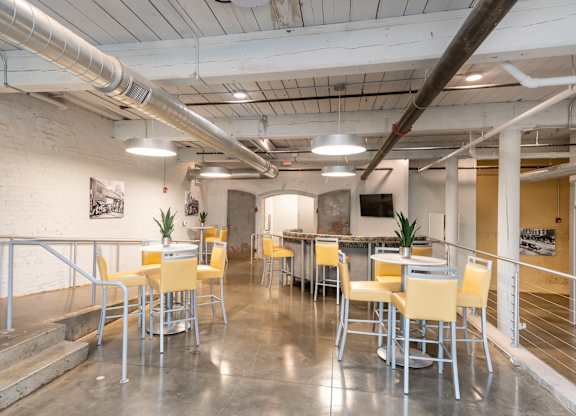 Converse Mill Lofts co-working station with two tables and a TV