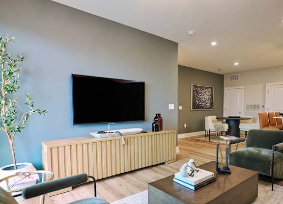 A living room with a flat screen TV mounted on the wall.