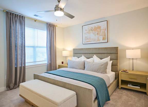 A bedroom with a large bed and a ceiling fan.