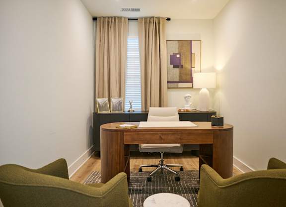 A room with a desk and two chairs.