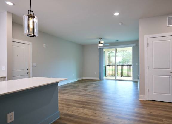 A room with a white counter and wooden floors.