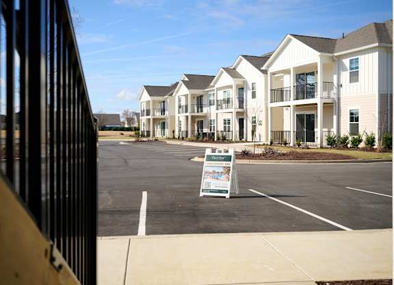 A sign in front of apartment buildings advertises a community event.