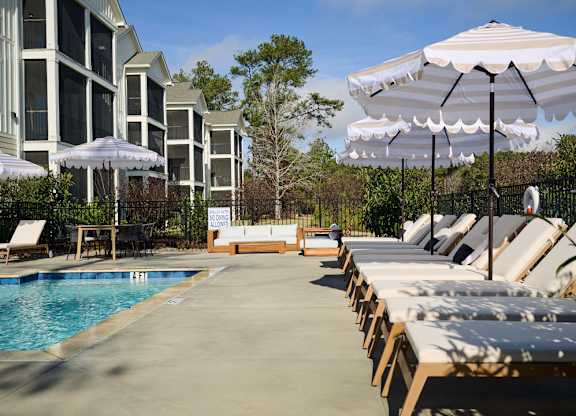 A poolside area with sun loungers and umbrellas.