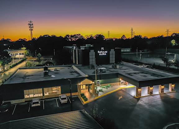 A building with the sign "flothouse studios" is lit up at dusk.